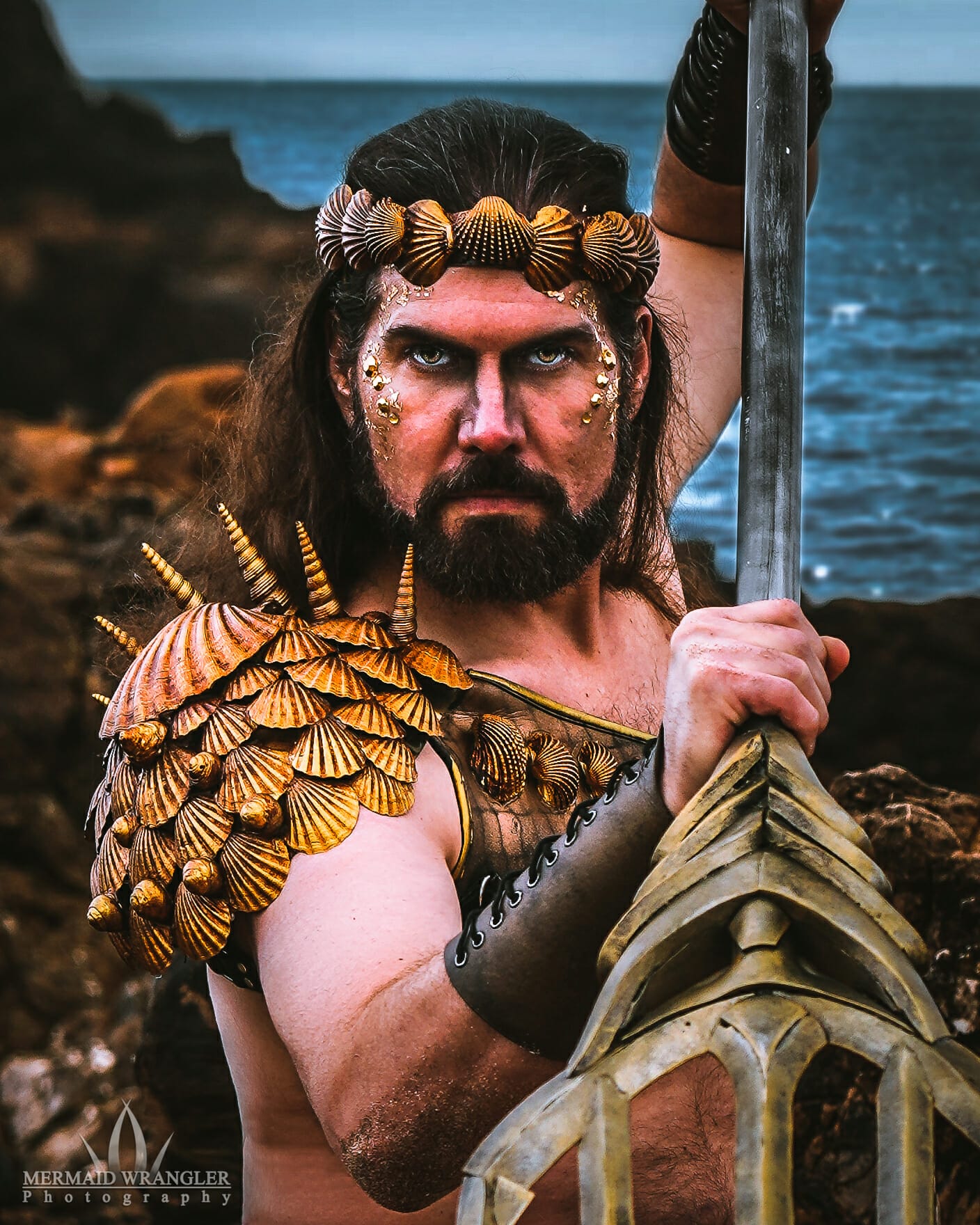 A man dressed as a merman holding a sword.