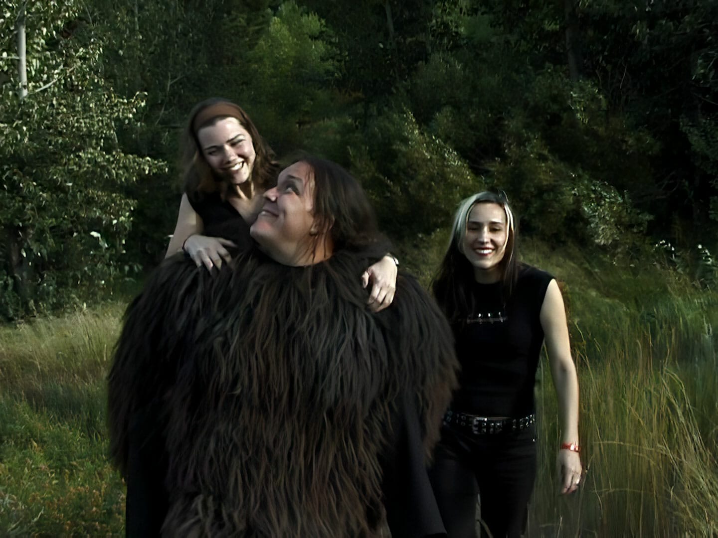 Two women dressed as Groovie Ghoulies standing next to a man dressed as a bigfoot at the Monster Club.