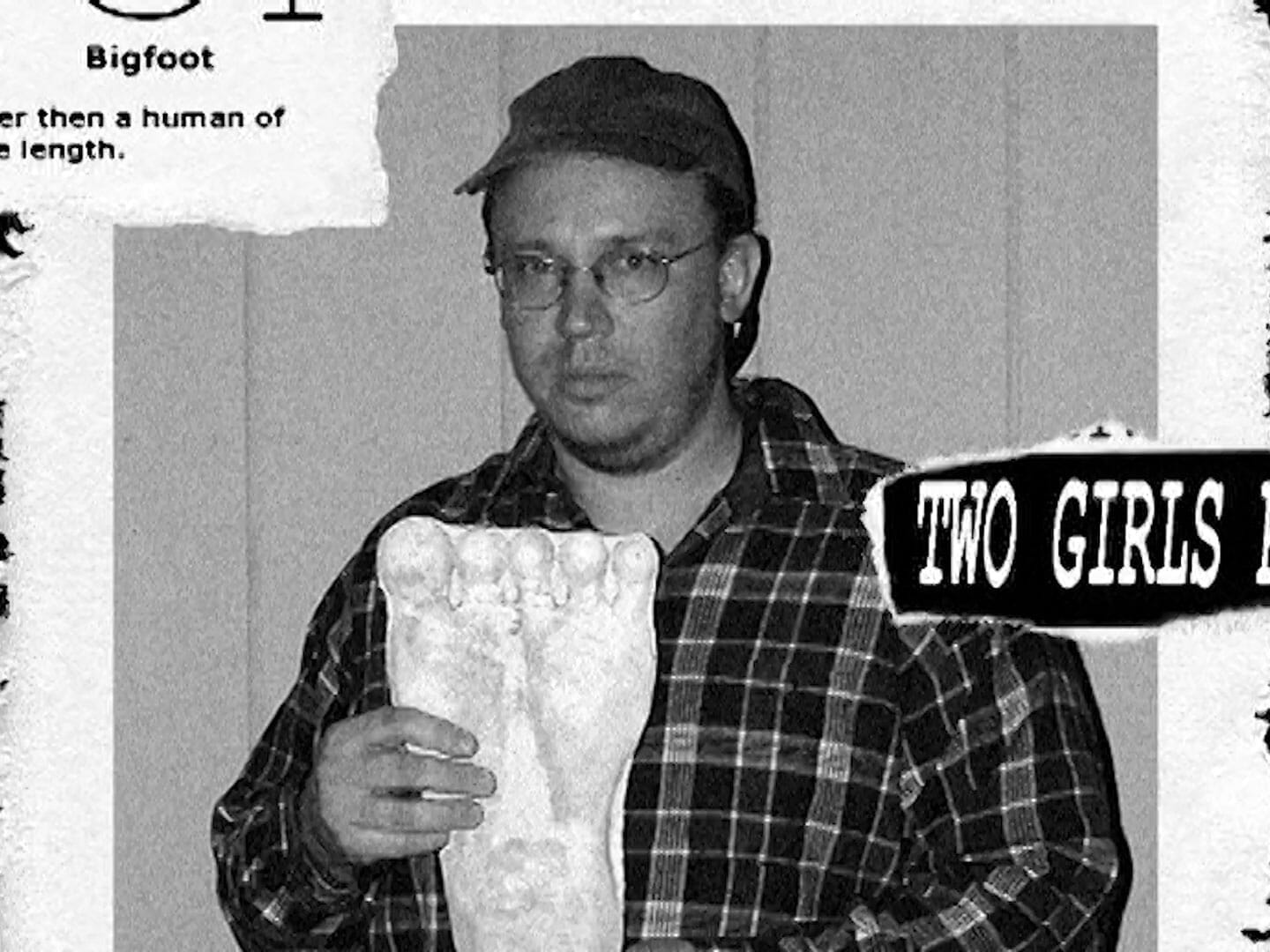 A man holding a foot in the Running with Bigfoot Music Video.