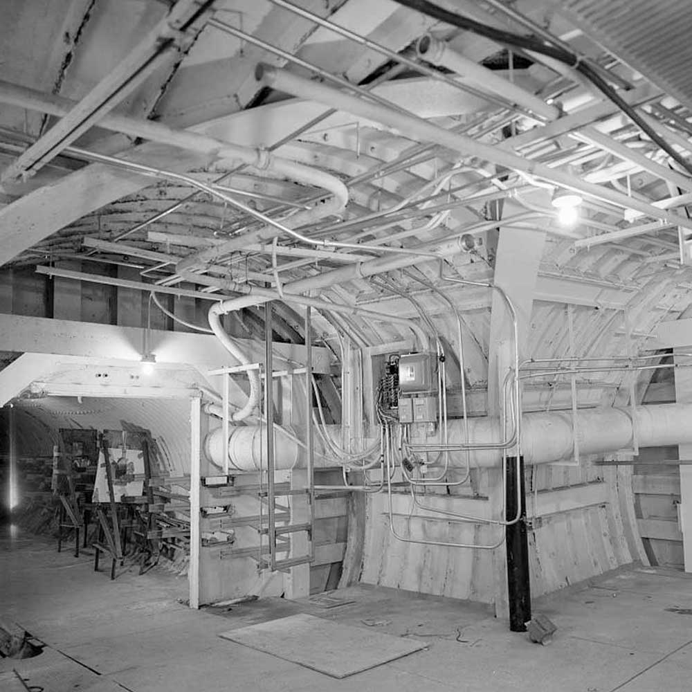 A black and white photo of a room with pipes and pipes.