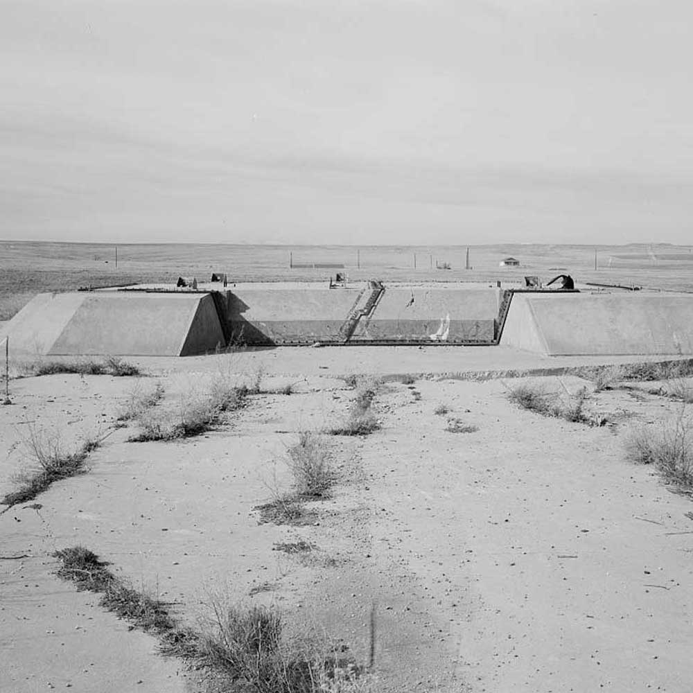 A black and white photo of a skate park in the desert.