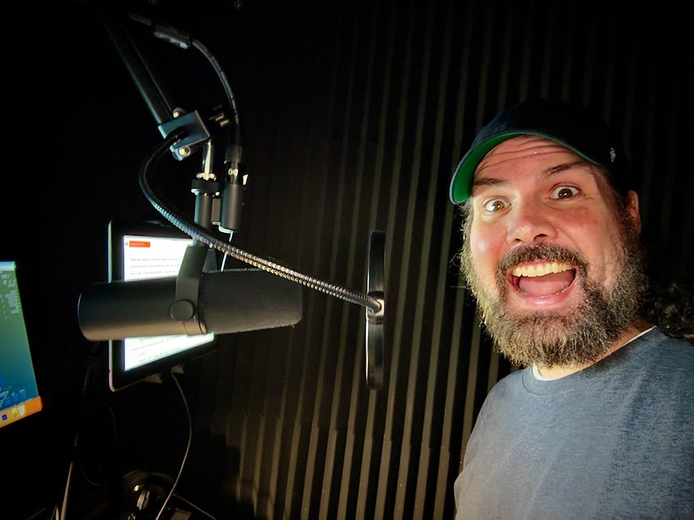 A man with a beard in front of a microphone.